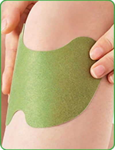 Green adhesive patch being applied to a person's skin on a white background